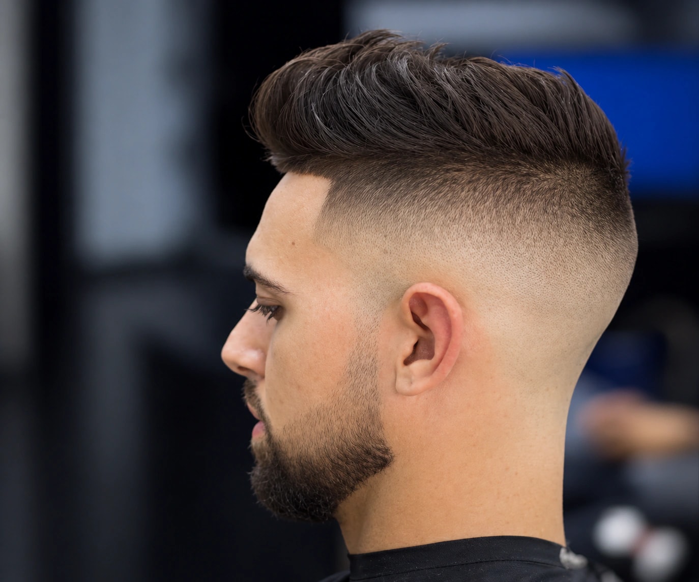 Dégradé haut, dessus relevé en pompadour et barbe courte aux contours nets