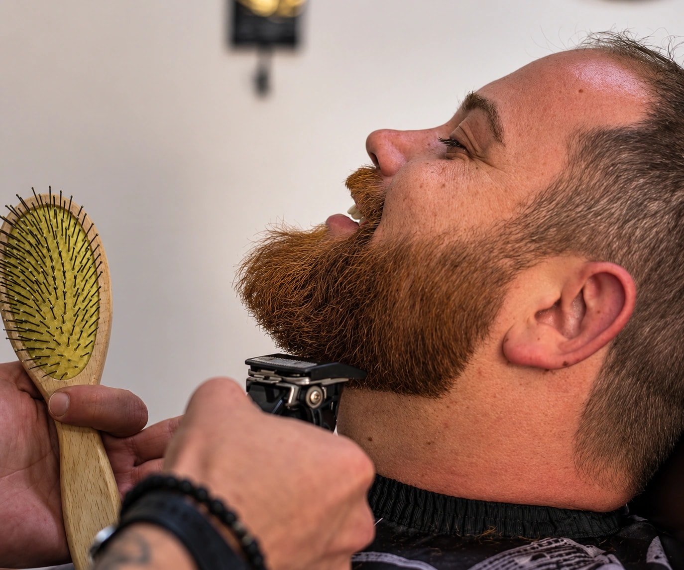 Barbier travaillant les contours d’une barbe à la tondeuse